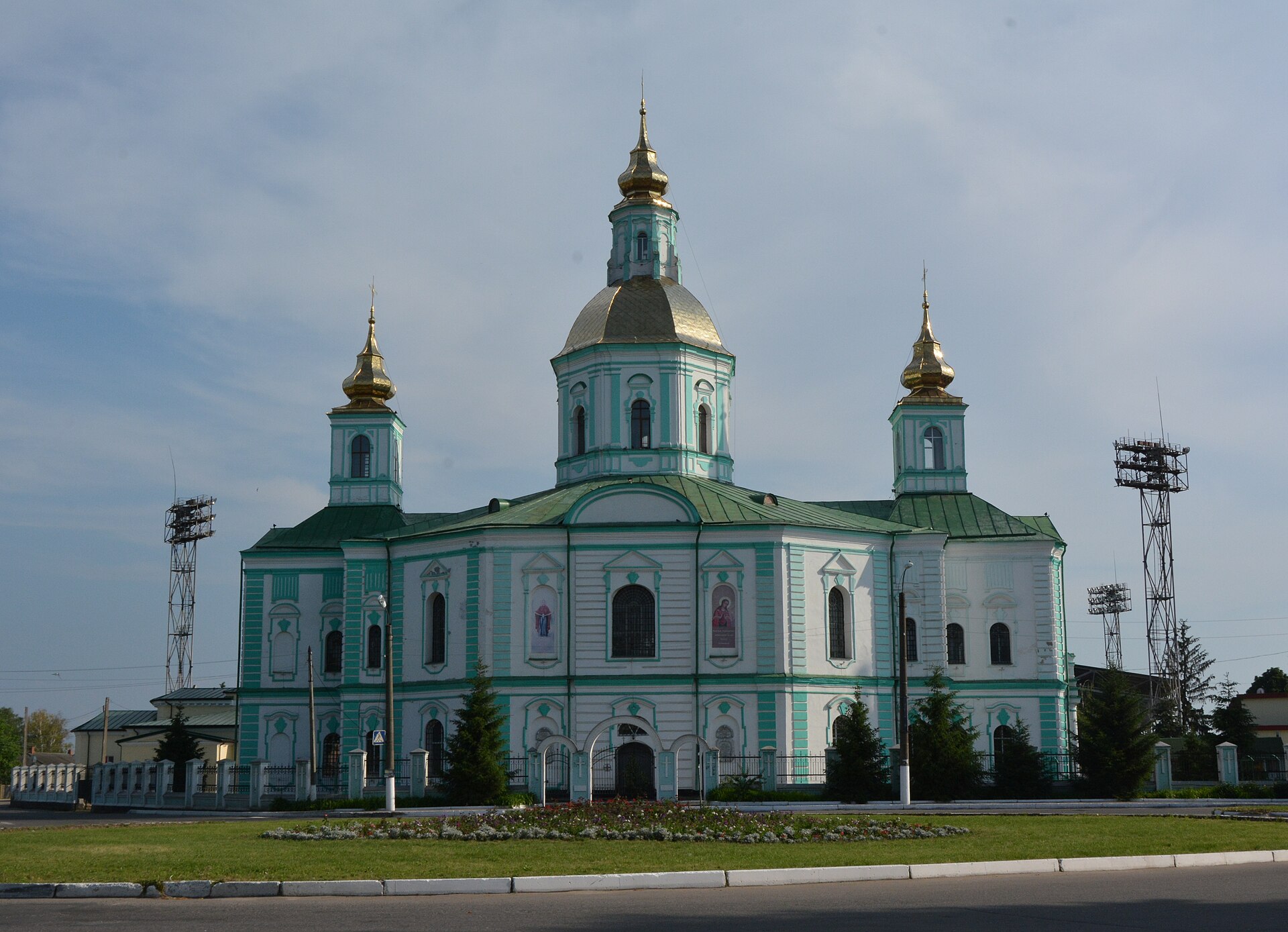 Покровський собор в Охтирці: зелено-білий бічний фасад, високий центральний верх і два нижчі верхи