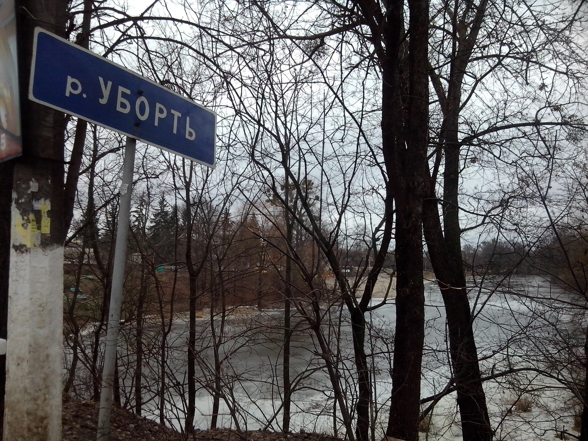 Уборть в Олевську за голими деревами; ліворуч видно синю табличку з назвою річки.